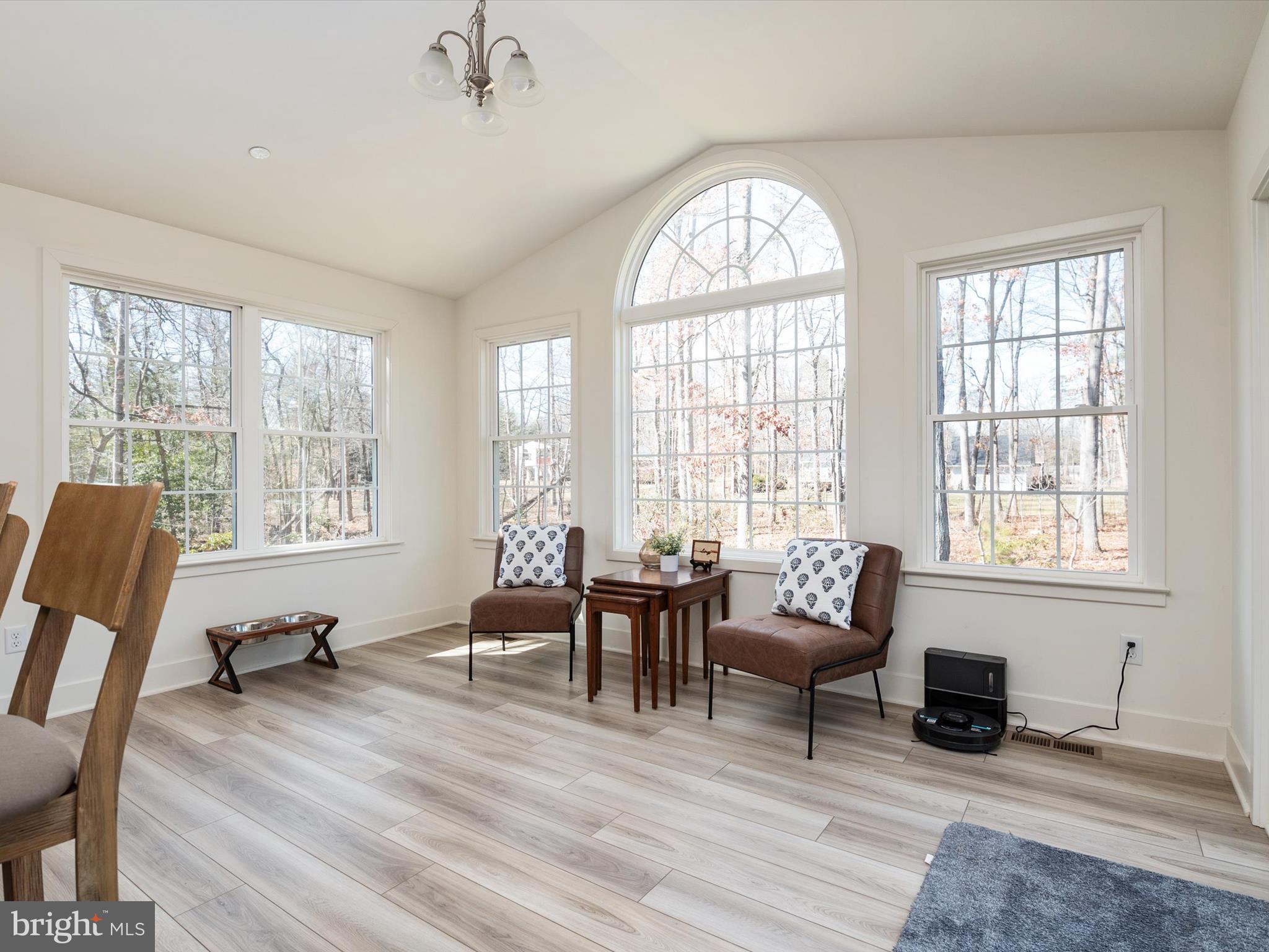 8412 Maryland Road Pasadena, MD 21122 - Photo 22 of 61 a living room with furniture floor to ceiling windows and a wooden floor