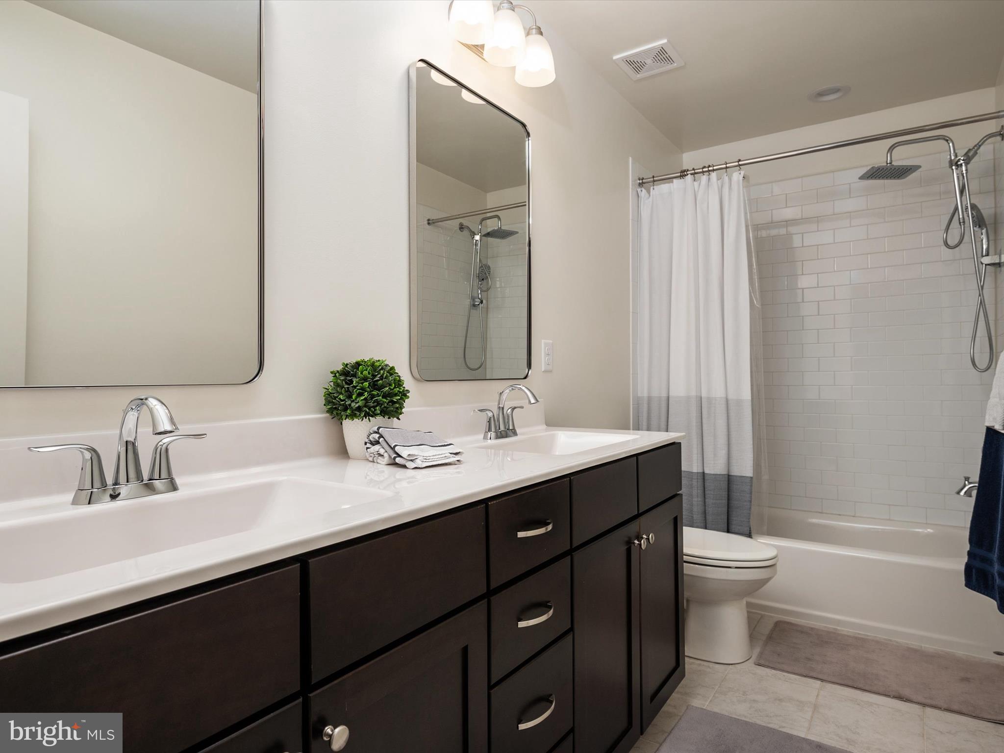 8412 Maryland Road Pasadena, MD 21122 - Photo 36 of 61 a bathroom with a double vanity sink toilet and a mirror