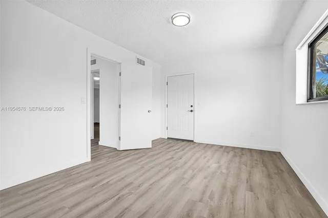 a view of an empty room with wooden floor