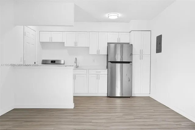 a view of a kitchen with a refrigerator a microwave and a sink