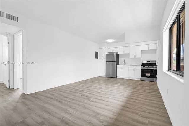 a view of empty room with wooden floor