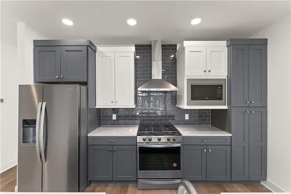 a kitchen with stainless steel appliances granite countertop a refrigerator a stove and a sink