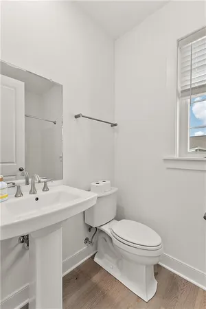 a bathroom with a toilet a sink and mirror