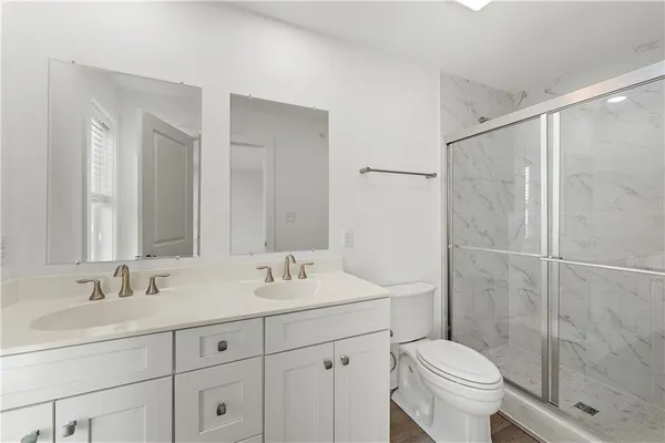 a bathroom with a sink toilet a mirror and shower