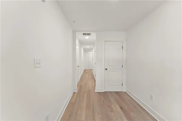 a view of a room with wooden floor and white doors