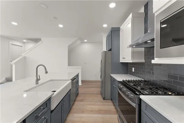 a kitchen with kitchen island stainless steel appliances a sink stove top oven and cabinets