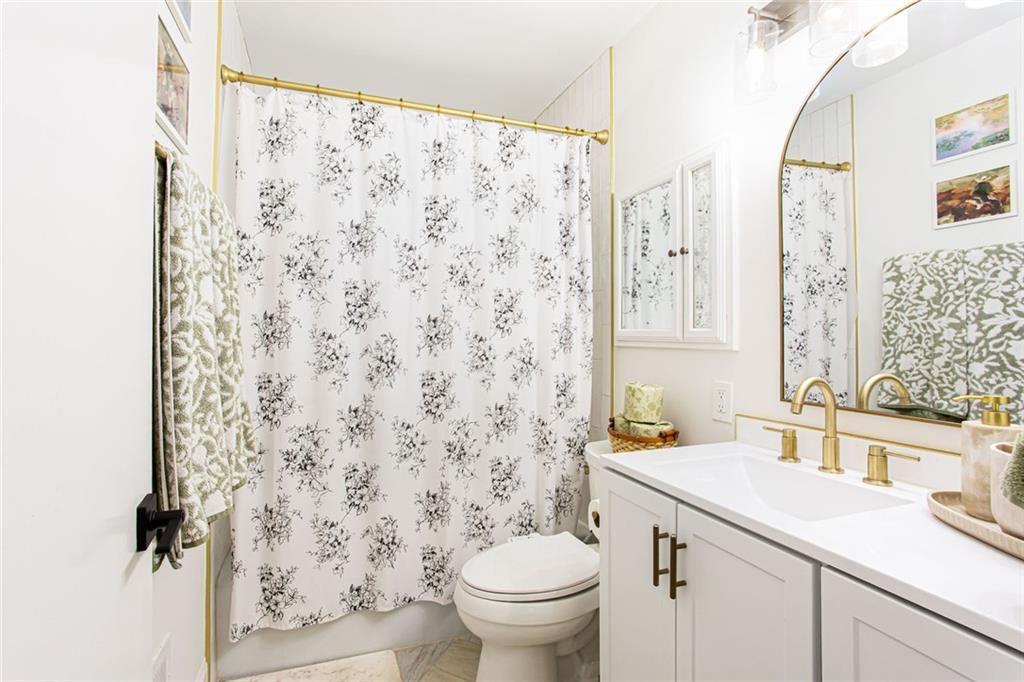 2814 Goodfellows Road Tucker, GA 30084 - Photo 25 of 46 a bathroom with a granite countertop sink a toilet and a mirror