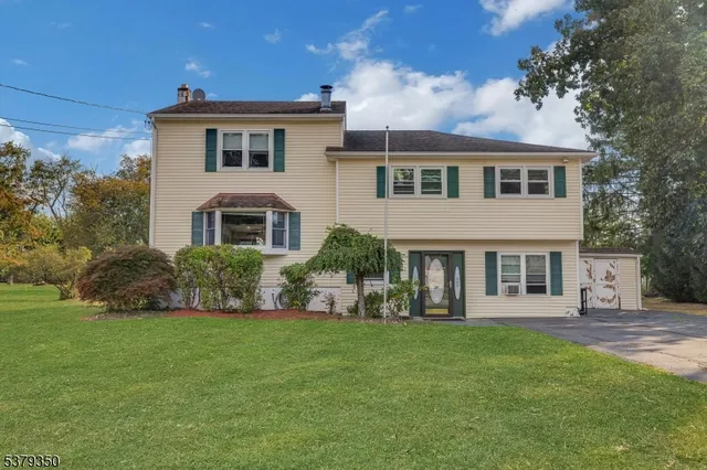 a front view of a house with a garden and yard