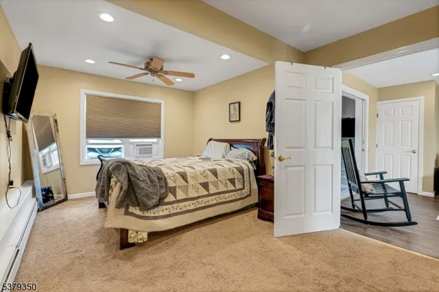 a spacious bedroom with a bed and a flat screen tv