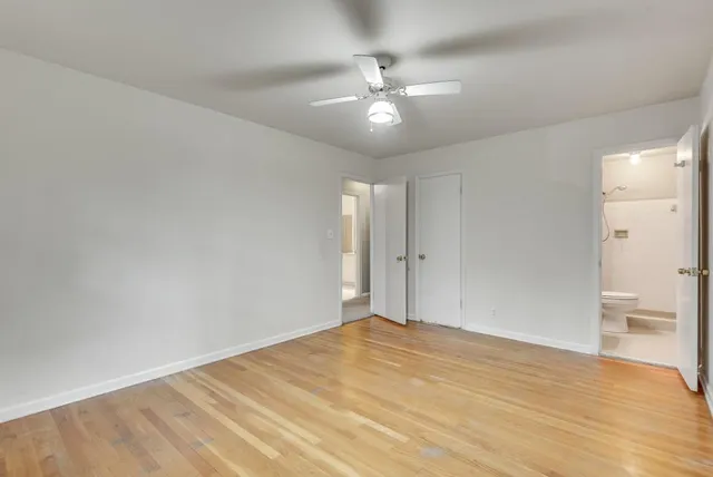 a view of an empty room and chandelier fan