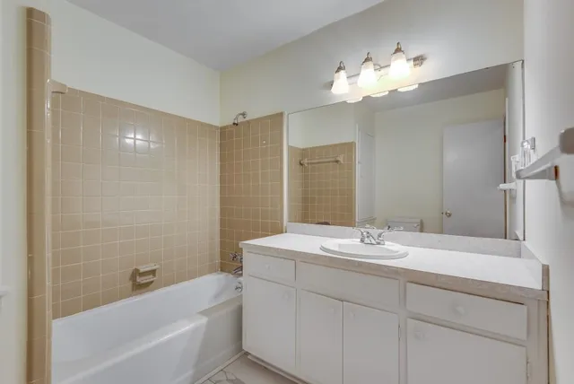 a bathroom with a sink a large mirror and a bathtub