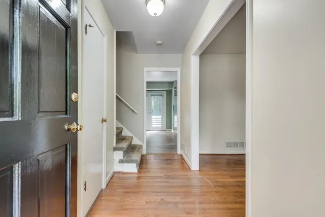 a view of a hallway with wooden floor and staircase