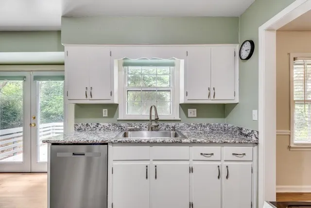 a kitchen with granite countertop a sink cabinets and window