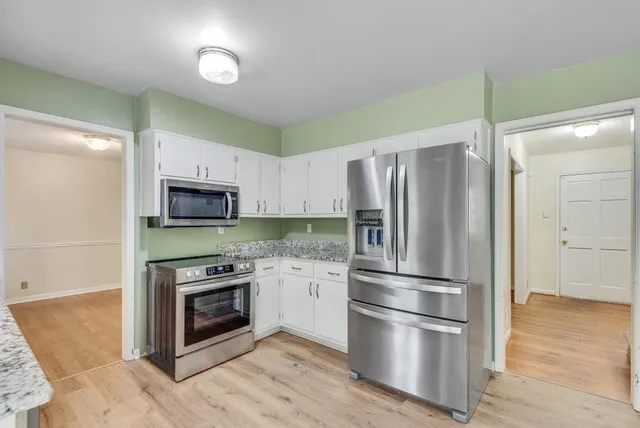 a kitchen with stainless steel appliances granite countertop a refrigerator and a stove top oven