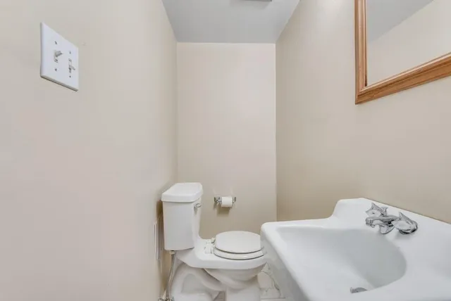 a white toilet sitting next to a bathroom sink