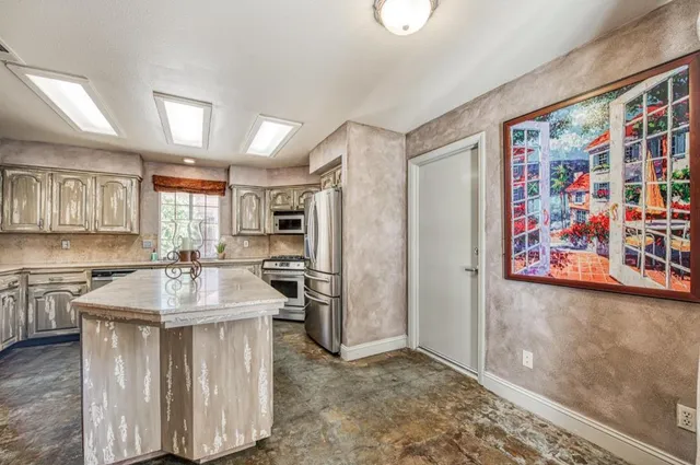 a kitchen with stainless steel appliances granite countertop a sink stove and cabinets