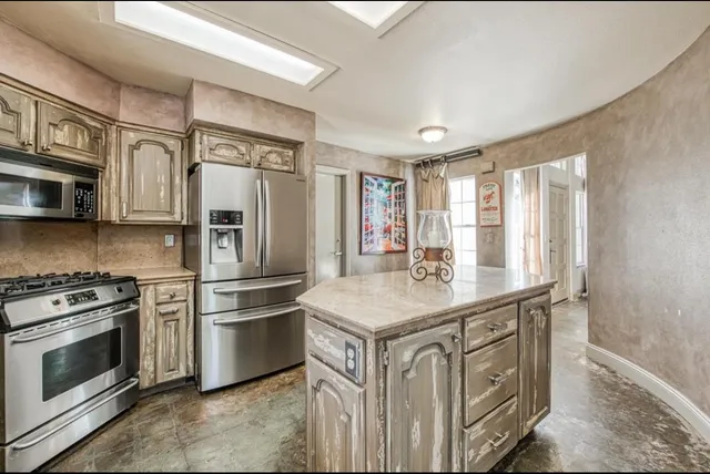 a kitchen with stainless steel appliances granite countertop a stove a refrigerator and a sink