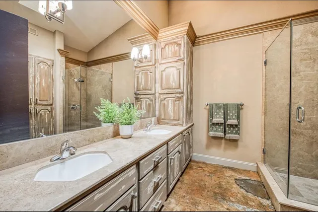 a bathroom with a granite countertop sink a mirror a vanity and a shower