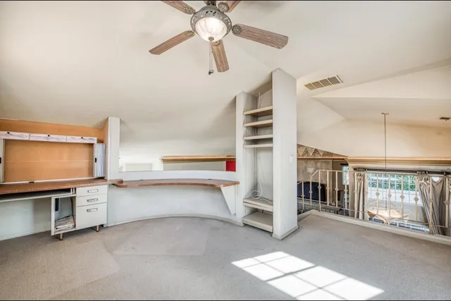 a view of a livingroom with furniture staircase and a ceiling fan