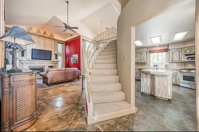 a living room with furniture a flat screen tv and kitchen view