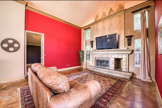 a living room with furniture a flat screen tv and a fireplace