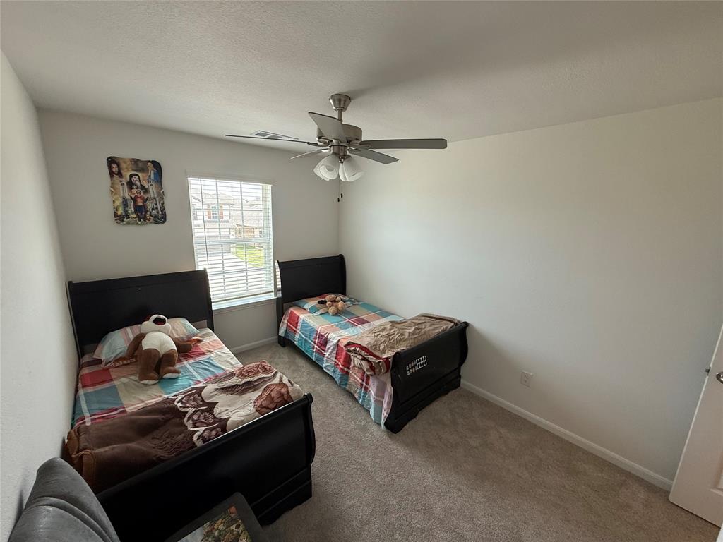 2006 Placerville Street Forney, TX 75126 - Photo 27 of 35 Bright room featuring a window with blinds, a ceiling fan with light fixture, light neutral-toned walls, and grey carpet flooring