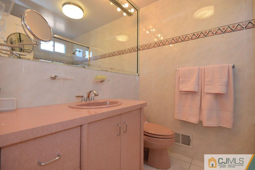 27 Thomas Road East Brunswick, NJ 08816 - Photo 14 of 24 a bathroom with a sink a toilet and shower