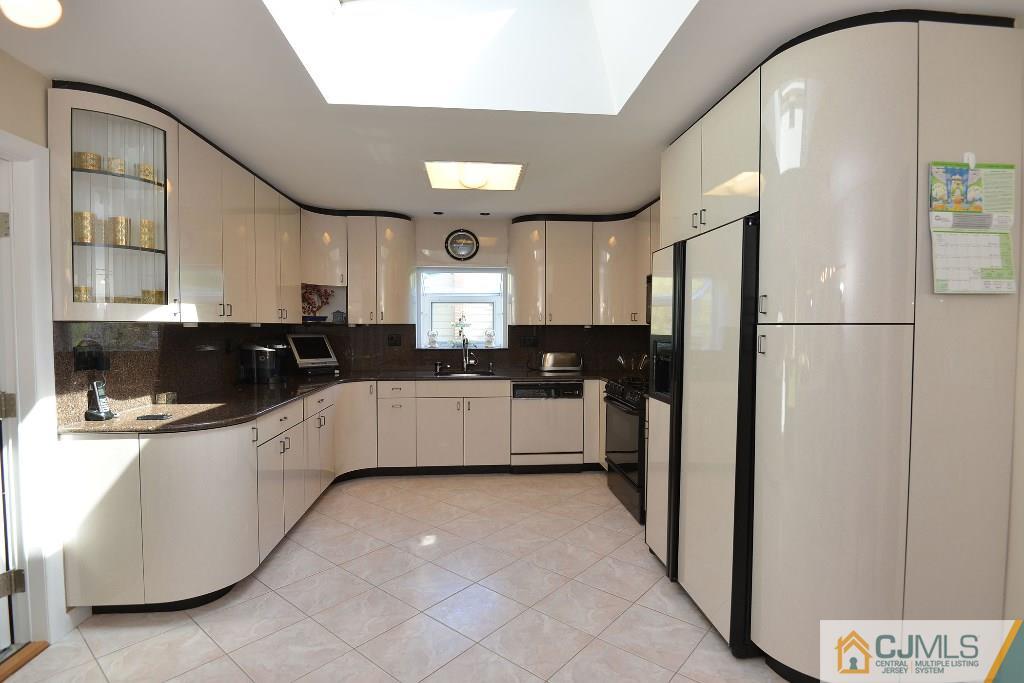 27 Thomas Road East Brunswick, NJ 08816 - Photo 9 of 24 a kitchen with a refrigerator a sink and cabinets