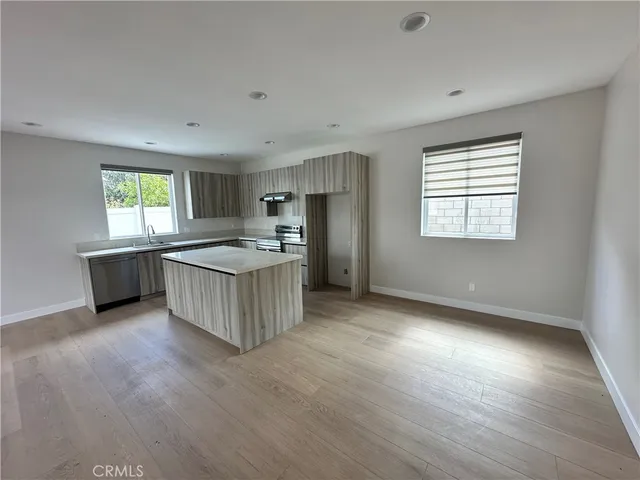 a large kitchen with hardwood floor and a sink