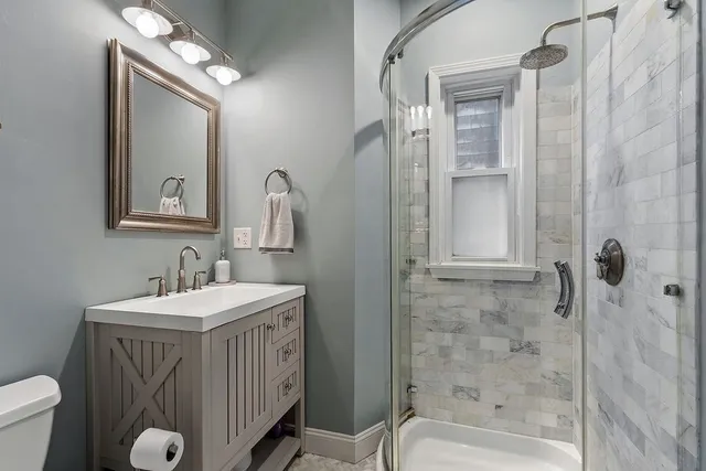 a bathroom with a sink a toilet and shower