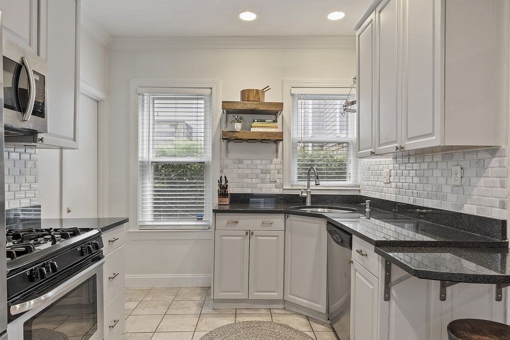 192 West Fifth Street, Unit 1 Boston, MA 02127 - Photo 10 of 24 a kitchen with granite countertop a sink stove and cabinets