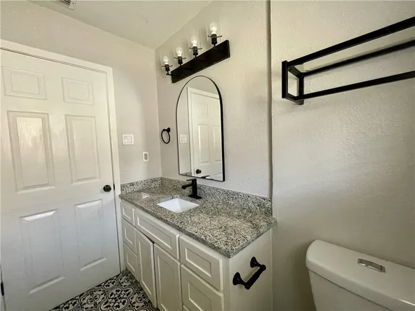a bathroom with a granite countertop sink and a mirror