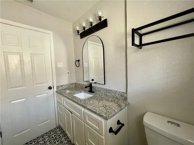 a bathroom with a granite countertop sink and a mirror
