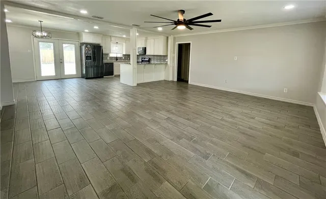 a view of empty room with wooden floor