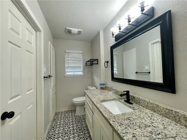a bathroom with a granite countertop sink a mirror and a shower