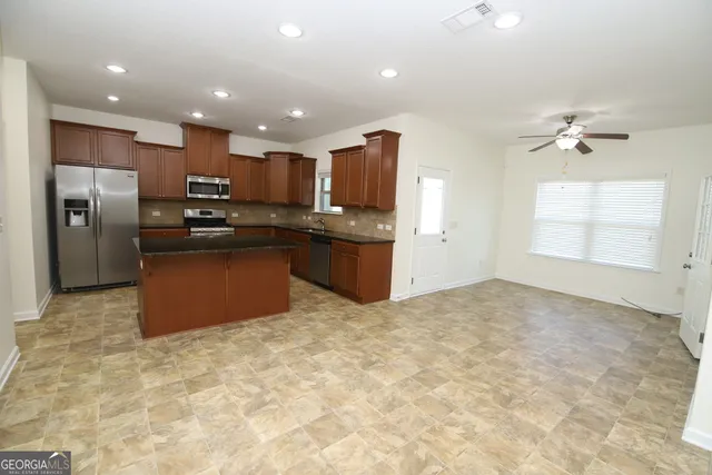 a kitchen with stainless steel appliances granite countertop a refrigerator and a sink