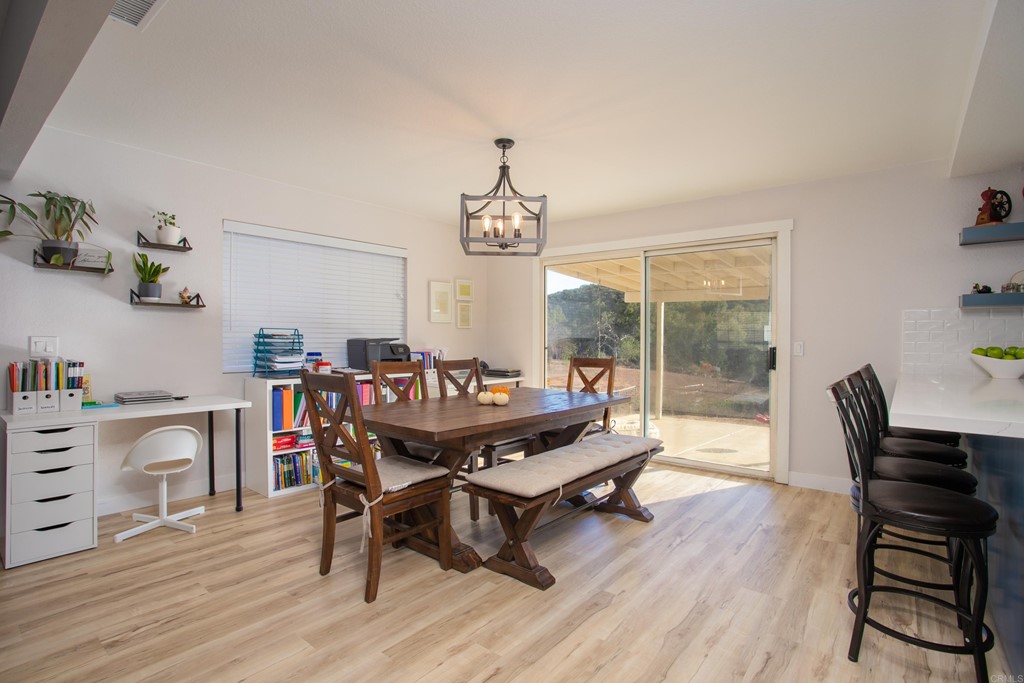 25929 Matlin Road Ramona, CA 92065 - Photo 11 of 19 a dining room with furniture a chandelier and wooden floor
