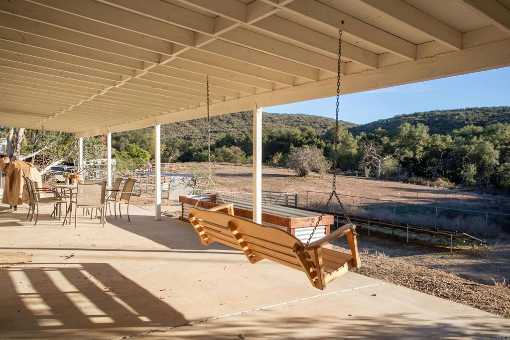 25929 Matlin Road Ramona, CA 92065 - Photo 16 of 19 a view of a patio with a table and chairs under an umbrella