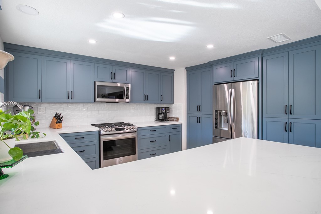 25929 Matlin Road Ramona, CA 92065 - Photo 5 of 19 a kitchen with stainless steel appliances a stove a sink a refrigerator a microwave and cabinets