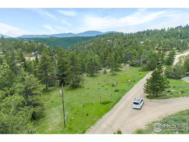 a view of a green field with mountains in the background