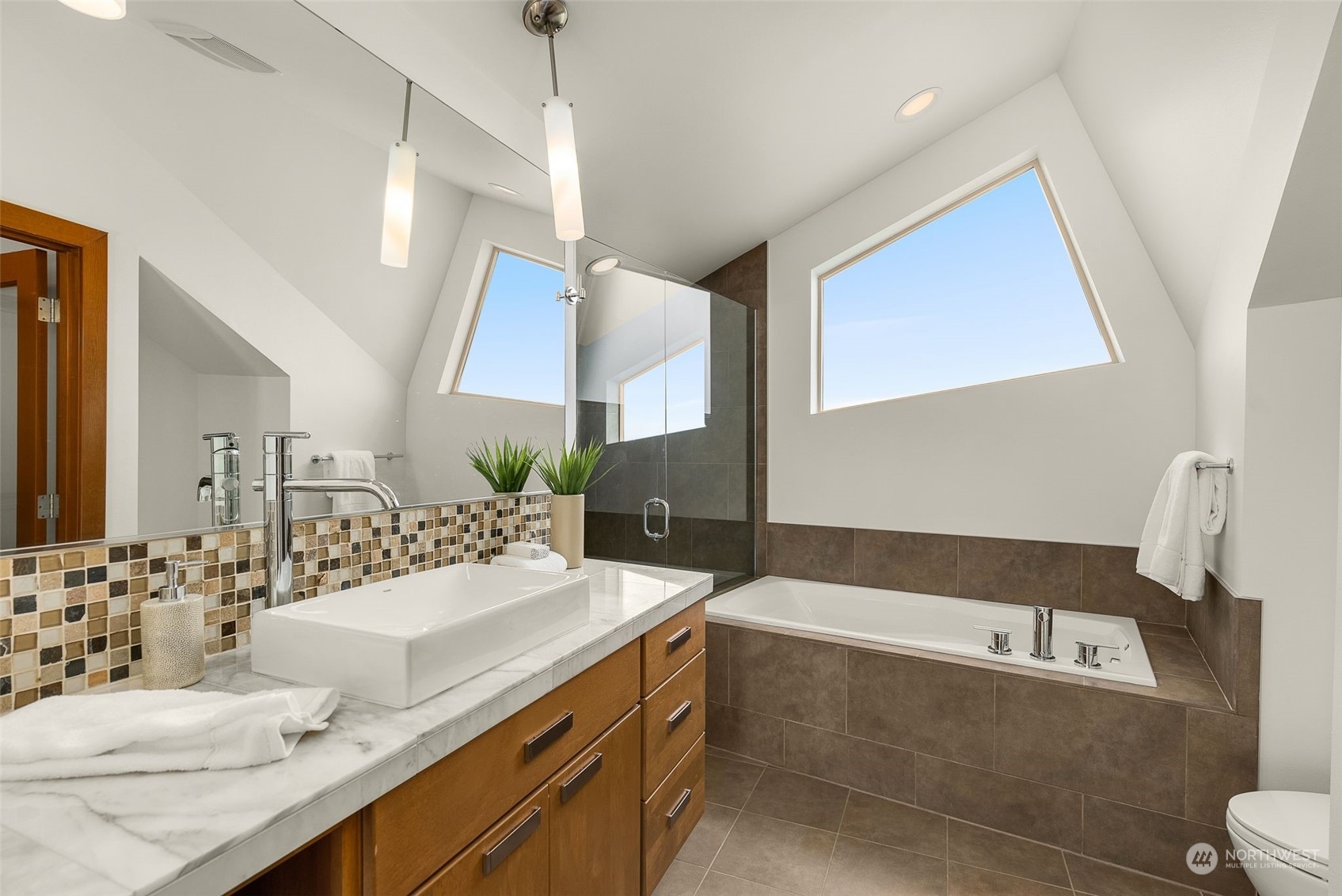 723 North 42nd Street Seattle, WA 98103 - Photo 21 of 27 a bathroom with a double vanity sink a mirror and a bathtub