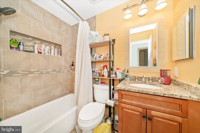 a bathroom with a granite countertop toilet sink and mirror