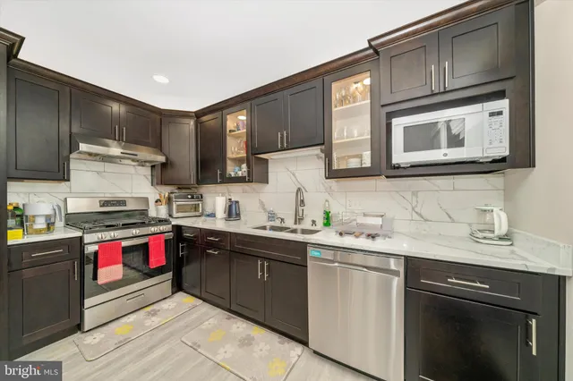 a kitchen with stainless steel appliances granite countertop a sink stove and cabinets