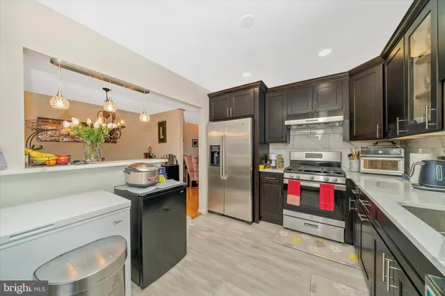 a kitchen with stainless steel appliances kitchen island granite countertop a refrigerator stove and sink
