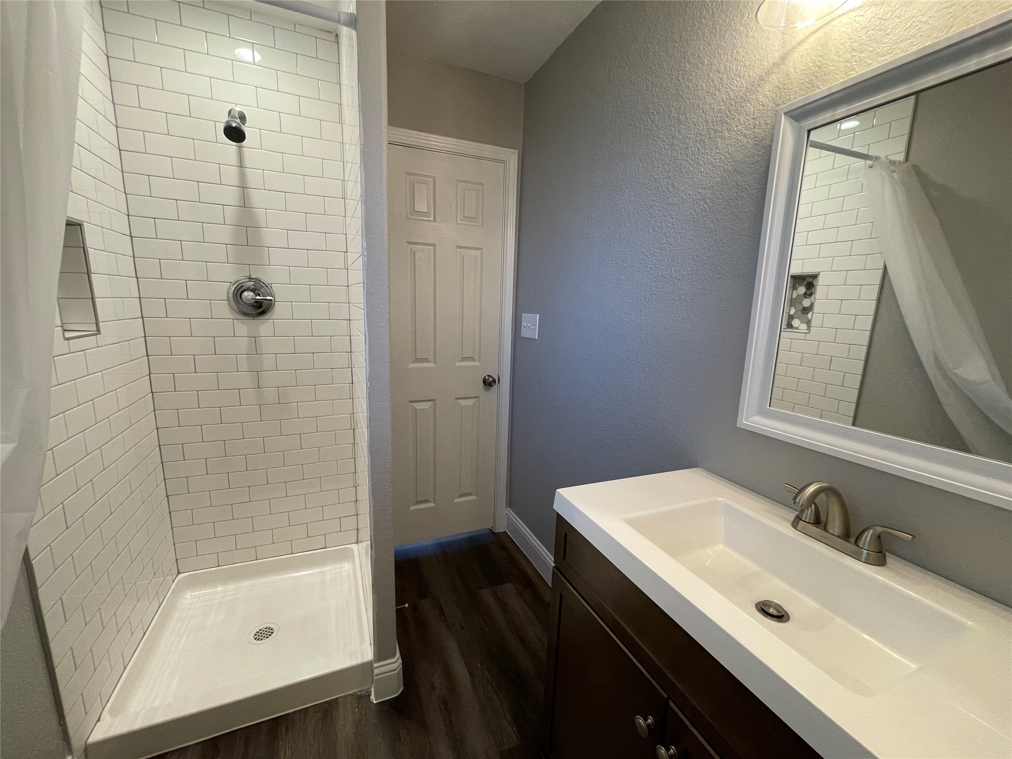 2004 Maple Street Georgetown, TX 78626 - Photo 23 of 31 Bathroom featuring a walk-in shower with white subway tile, a built-in shower niche, and a white shower pan