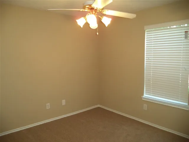 a view of a room with window and a fan