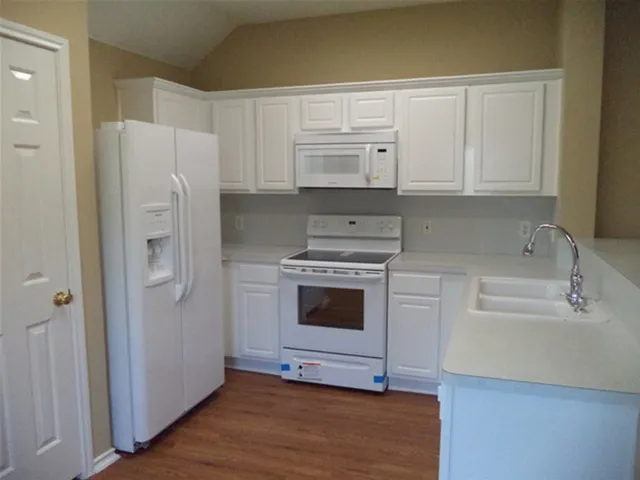a kitchen with stainless steel appliances white cabinets and a refrigerator