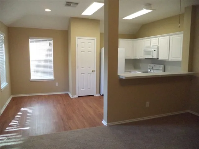 an empty room with wooden floor and a window