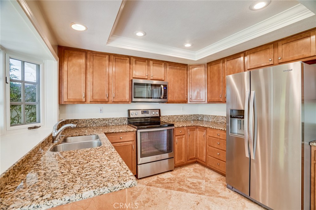 49 East Yale Loop, Unit 26 Irvine, CA 92604 - Photo 14 of 63 a kitchen with granite countertop appliances a sink and a window
