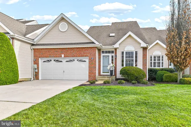 a view of a big house with a big yard and large tree